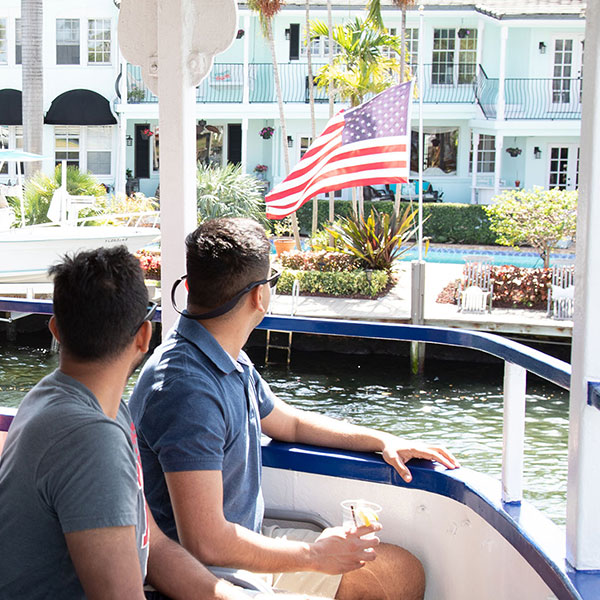open-air cruising Couple looking at mansion with American flag